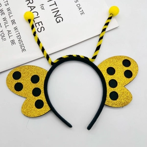 Detail of bee headband with yellow fuzzy antennas and gold glitter wings for parties