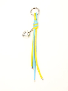 Detail of blue and yellow braided leather keychain with silver heart pendant macro view