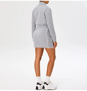 Back view of a grey slim-fit cropped sports jacket and mini skirt with white side stripes