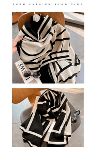 Detail of black and white geometric pattern scarf with elegant tassel edges on a chair