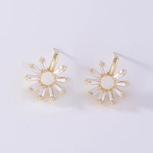 Detailed macro view of gold sunflower stud earrings featuring rectangular clear gemstones
