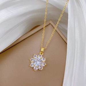 Macro shot of gold snowflake pendant necklace with sparkling cubic zirconia on silk fabric