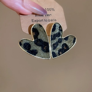 Close-up of leopard print heart earrings with gold metal edges on a display card