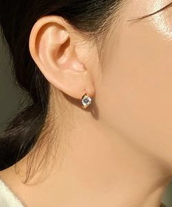 Close-up of a minimalist gold hoop earring featuring a brilliant round-cut cubic zirconia