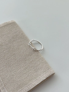 Detail shot of 925 sterling silver twisted rope knot ring on a beige linen fabric