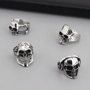 Dettaglio di quattro anelli a teschio in argento gotico stile punk con finitura lucida