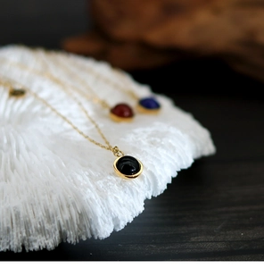 Detail of round agate pendant necklaces in diverse colors on 18K gold titanium chains