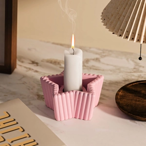 Makro-Detail eines rosa sternförmigen Kerzenhalters mit eleganter vertikaler Streifen-Struktur