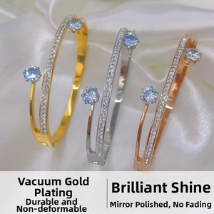 Three-color titanium steel open bangles with blue zircon stones on silk fabric