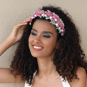 Close-up of pink fabric roses and white pearls on a stylish floral headband