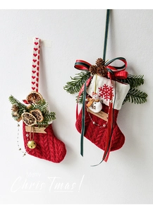 Detalle de calcetines de Navidad de punto rojo con piñas y adornos de muñeco de nieve