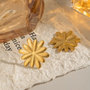 Vintage gold petal earrings made of stainless steel displayed on decorative paper