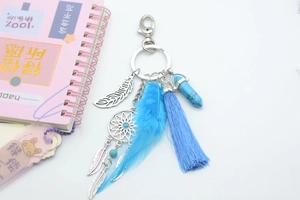 Detail of bohemian dreamcatcher keychain with blue feathers and turquoise pendant