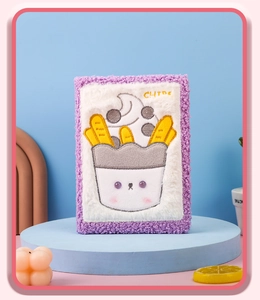 Detalle del cuaderno de peluche morado con bordado de patatas fritas y texto de CHIPS