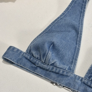 Dettaglio della trama del top denim con cuciture precise e fibbia metallica lucida