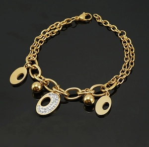 Detailed macro view of 18K gold plated double-layer bracelet with crystal charms on black surface