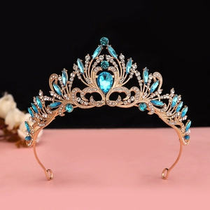 Detail of golden baroque crown featuring sky blue crystals and sparkling rhinestones