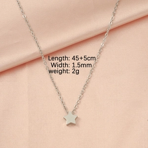 Detail showing a 45+5cm silver star pendant necklace on pink silk fabric background