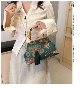 Details von Bambusgriff und Goldstickerei auf grüner Satin-Tasche im Asia-Stil