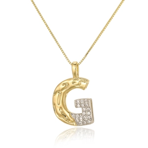 Macro detail of gold letter G pendant with cubic zirconia inlay on a box chain