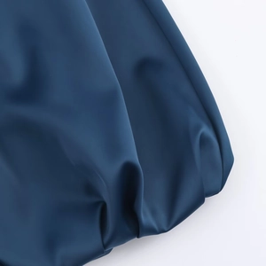 Detailed view of dark blue satin fabric texture and elegant pleated folds on the dress
