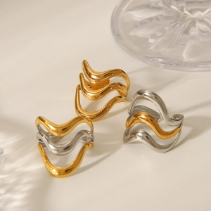 Macro detail of triple-layered wavy rings in gold and silver polished stainless steel