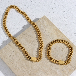 Golden Cuban link chain necklace and bracelet set with box clasp on marble surface