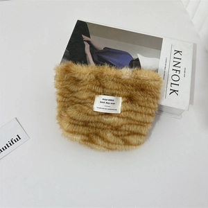 Detail shot of vintage plush brown leopard makeup bag on white marble with magazine
