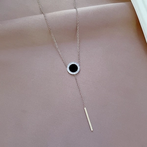 Macro detail of silver Y-shaped titanium steel necklace with Roman numeral pendant