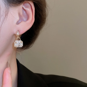 Macro shot of gold lock earrings featuring cubic zirconia set in high-quality alloy base
