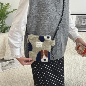 Close-up of fluffy cream crossbody bag with blue dots and cute puppy graphic pattern