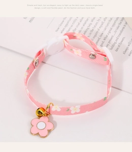 Detailed view of pink floral pet collar with 3D flower pendant and gold bell accessory