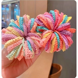 Élastiques à cheveux colorés aux tons acidulés avec texture plissée tenus en main