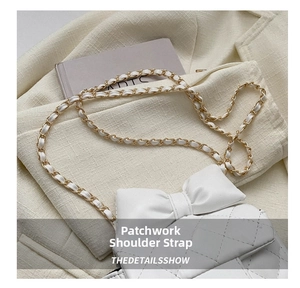 Close-up of white quilted bag with bow detail and metal chain stitched shoulder strap