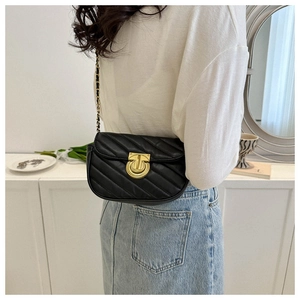 Detail of black crossbody bag featuring V-shaped quilting and a gold circular lock