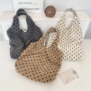 Dettagli di tre borse shopper in velluto a pois nei colori grigio, marrone e bianco