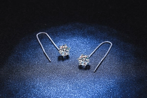 Macro shot of 925 sterling silver ear threads with six-prong moissanite setting