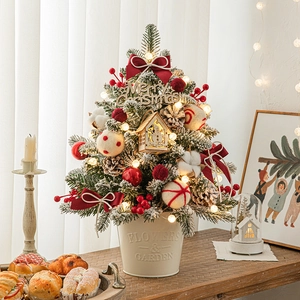 Mini DIY Christmas tree in iron bucket with pine cones, warm lights, and festive ornaments