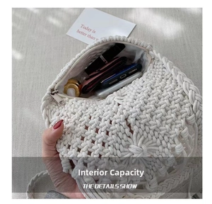 Detail view of the white crochet straw bag showing internal capacity with zipper closure
