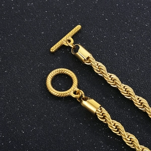 Detailed close-up of gold twist rope chain with a classic OT toggle clasp on dark surface