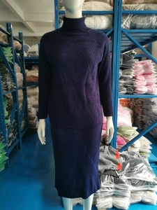 Detailed view of dark blue ribbed knit turtleneck sweater and matching skirt set
