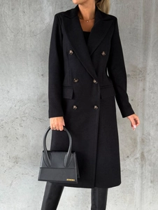 Detailed view of black double-breasted coat texture with buttons and a designer handbag