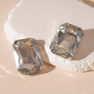 Macro shot of rectangular cut grey crystal claw rhinestones on a textured stone base