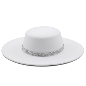White flat top wool fedora hat with silver sequin band and metal logo on white background