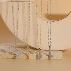 Detail of luxury rabbit pendants in gold and silver finish with zircon and resin stones