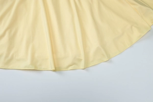 Close-up of the smooth hem stitching on a yellow V-neck slim fit dress fabric