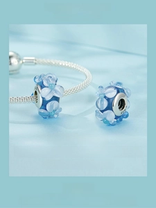 Macro shot of blue floral Murano glass bead with S925 sterling silver core detail