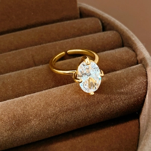 Macro detail of oval zircon stone in a 18k gold plated claw setting on a ring
