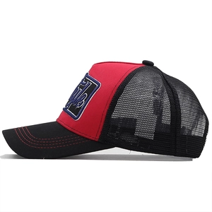 Close-up of trucker hat with red cotton panels, black mesh, and 3D embroidery detail