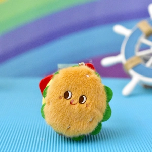 Detailed close-up of a cute plush burger-shaped keychain pendant with a soft fuzzy texture